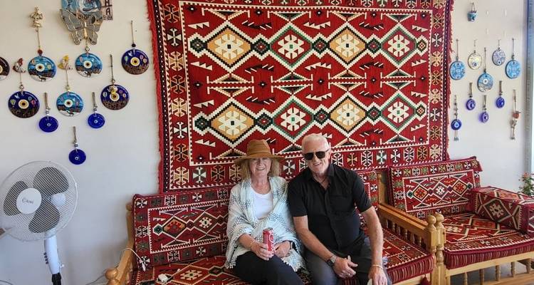 Pareja sentada dentro de una habitación decorada de manera tradicional.