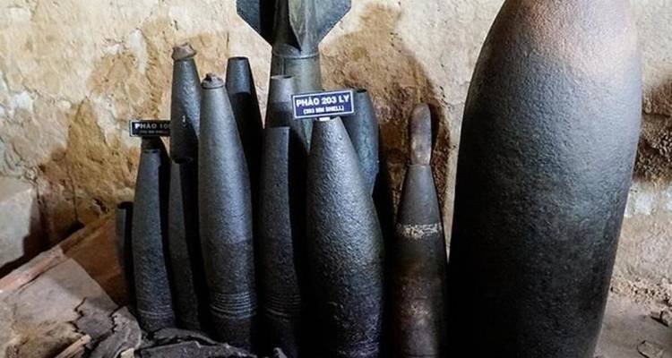 Collection of old artillery shells displayed upright.