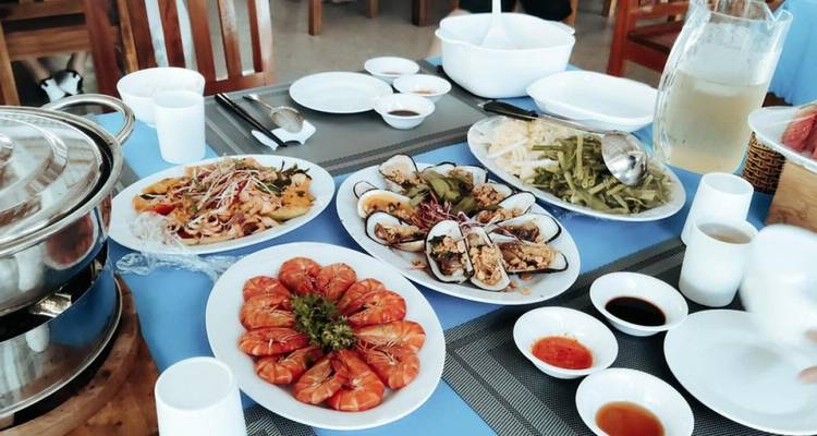 Table remplie de divers plats de fruits de mer et de sauces.