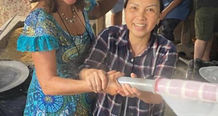 Deux femmes interagissant dans un cadre local, démontrant peut-être un artisanat traditionnel.