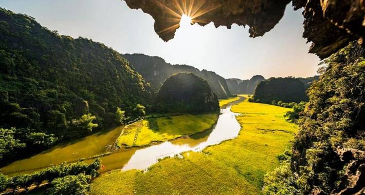 Schilderachtig uitzicht op een rivier en karstbergen met zonlicht dat erdoorheen breekt.