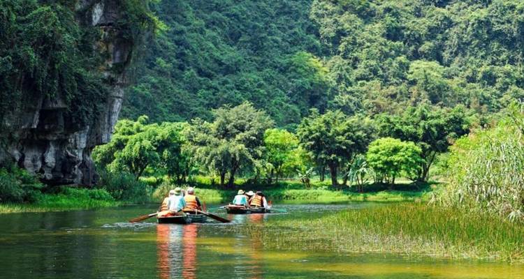 Toeristen die met boten peddelen door een schilderachtige rivier omringd door groen.