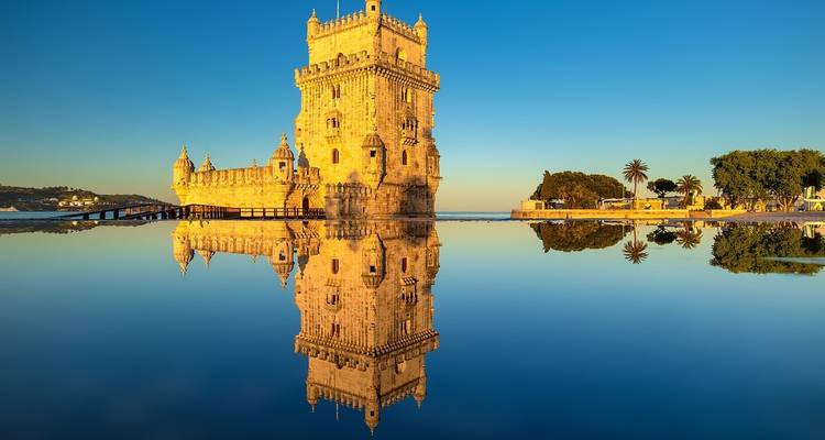 Turm von Belém spiegelt sich bei Sonnenaufgang im Wasser wider.