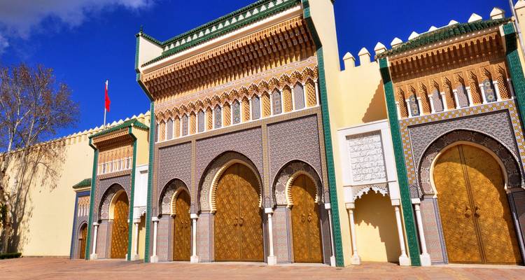 Muros del palacio con puertas doradas ornamentadas.