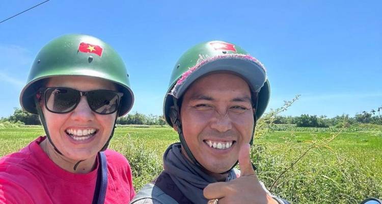 Deux personnes souriantes portant des casques avec un champ vert en arrière-plan.
