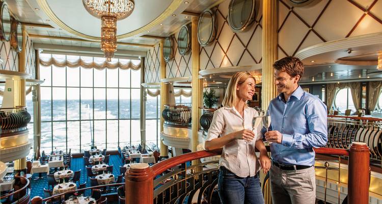 Couple trinquant avec des boissons sur un bateau de croisière avec vue sur la mer.