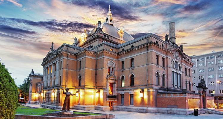 Illuminated historic building under a dramatic, colorful sky.