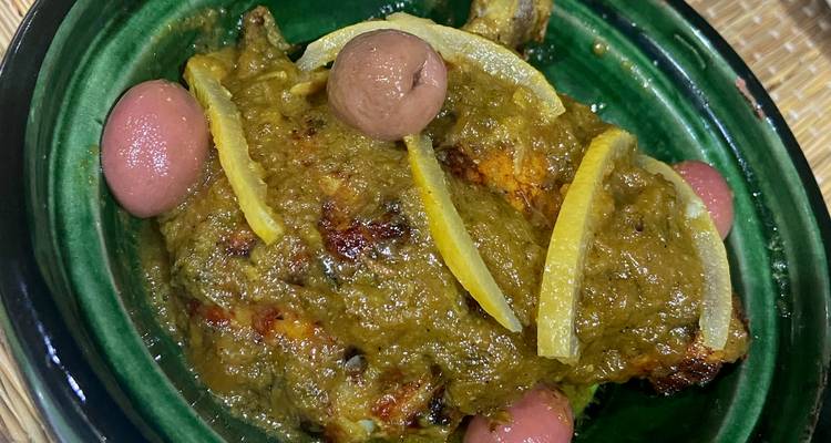 Nahaufnahme einer marokkanischen Tajine mit Oliven und eingelegter Zitrone.