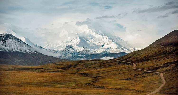 Verschneite Berglandschaft mit einer gewundenen Straße.