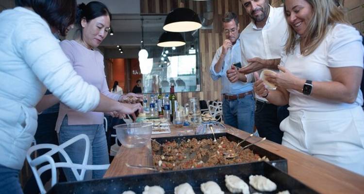 Menschen die deelnemen aan een kookles, samen eten bereiden.
