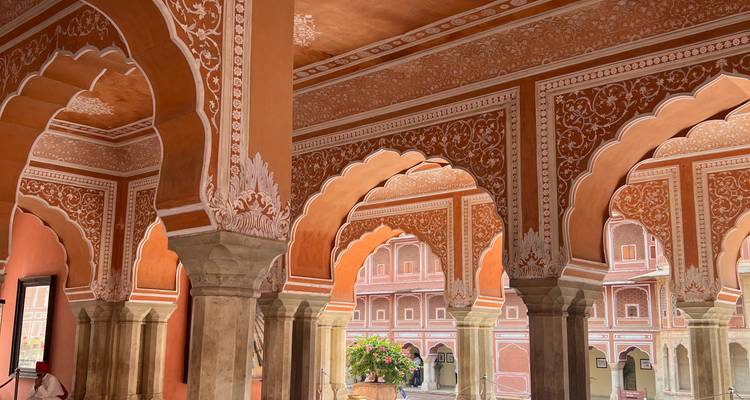 Des arches rose et orange finement décorées à l'intérieur de la cour ornée d'un palais indien.