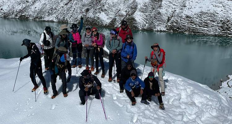 Groep wandelaars poserend op een besneeuwde bergpaden.