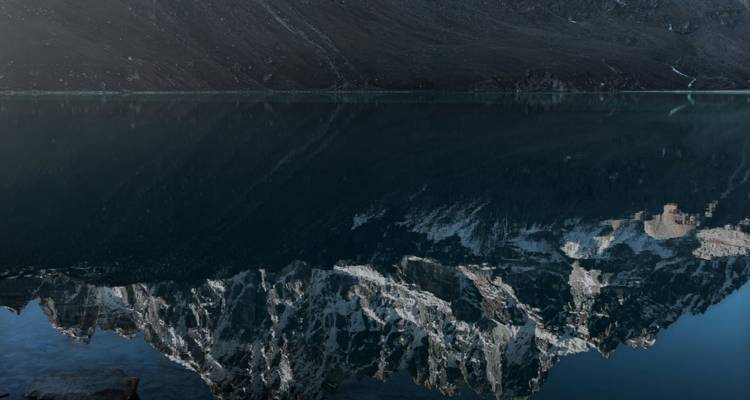 Reflectie van bergen in een kalm meer.