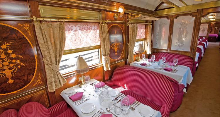 Interieur eetgedeelte van een luxetrein met gedekte tafels voor maaltijden