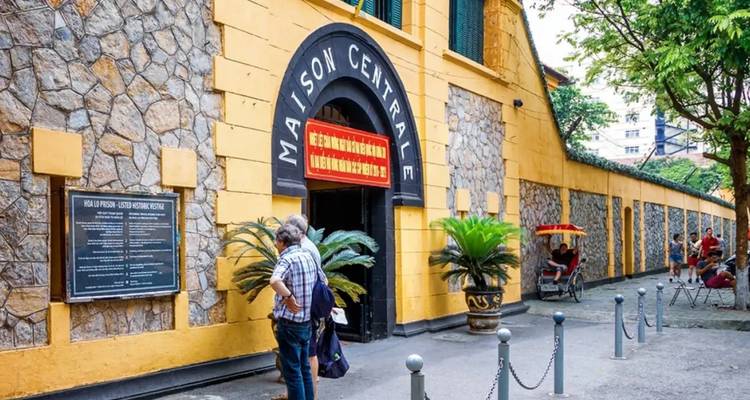 Vue extérieure de la prison de Hoa Lo avec des touristes à l'entrée.