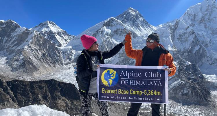 Twee mensen die een spandoek vasthouden bij Everest Base Camp.