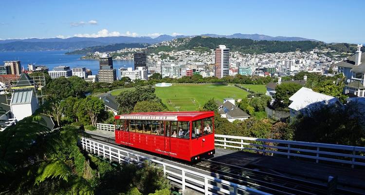 Red cable car overlooking a cityscape.
