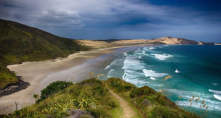 Clifftop view of a beach with waves hitting the shore.