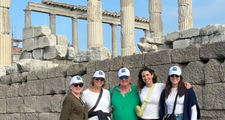 Turistas posando entre ruinas antiguas y columnas.