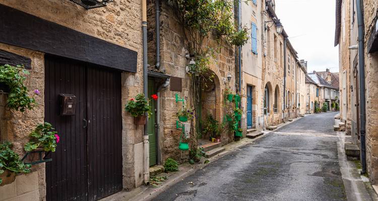 Una calle estrecha en un pueblo histórico con edificios de piedra.