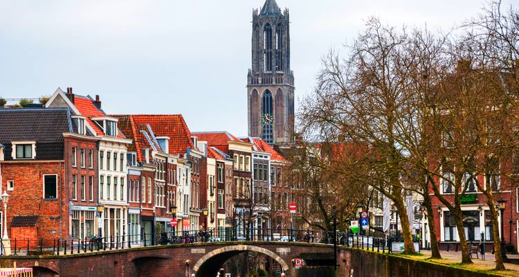 City scene with traditional Dutch buildings and the Dom Tower in Utrecht, Netherlands.