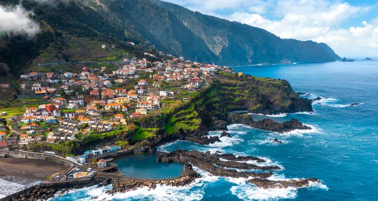 Un pueblo costero en un acantilado rocoso con olas del océano.