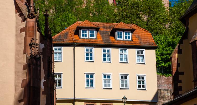 Een traditioneel Duits huis met oranje dak en kerktoren.