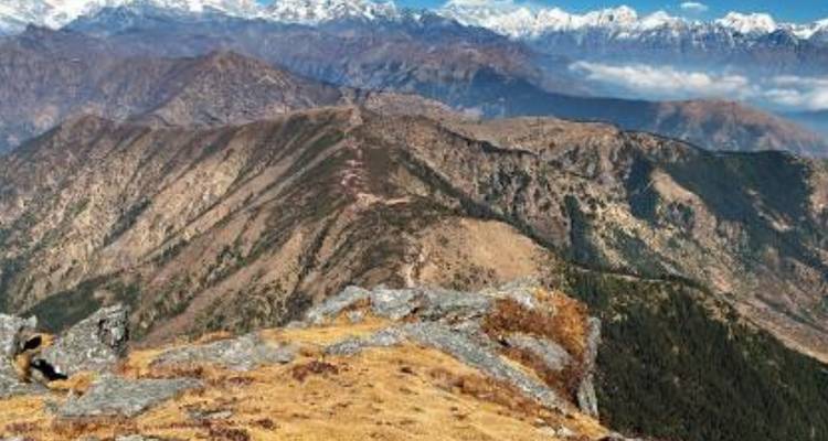 Blick von einem hohen Punkt auf eine zerklüftete Berglandschaft.