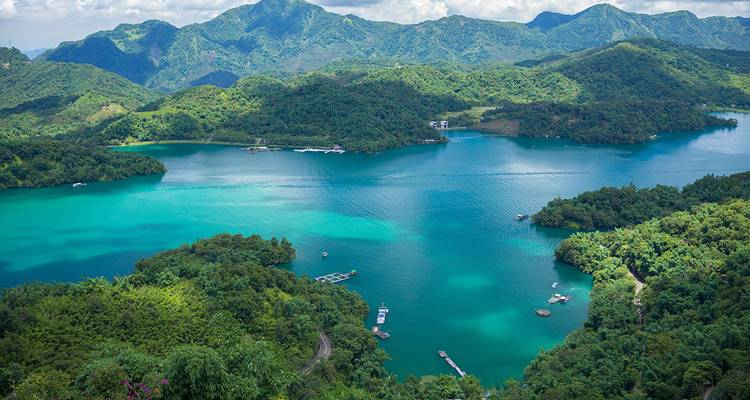 Serene meer omringd door weelderige groene bergen.