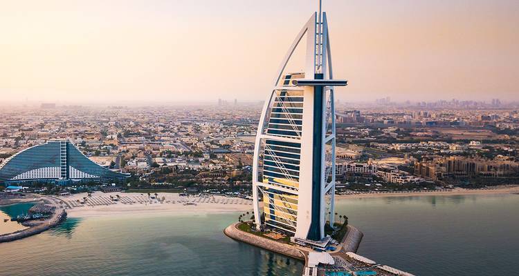 Ikonisches Hotel an einer Küste vor Stadthintergrund.