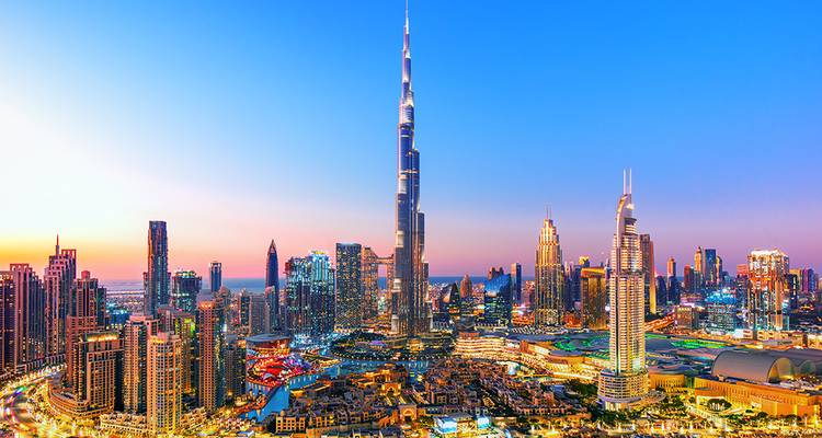 Stadtansicht mit einem markanten Turm in der Abenddämmerung.