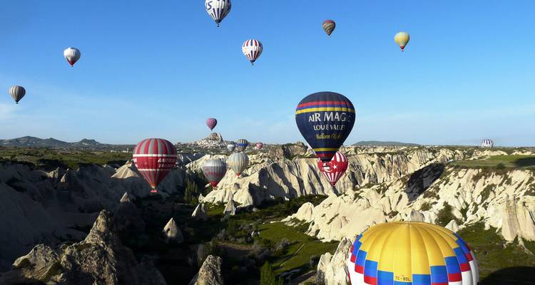 Montgolfières volant au-dessus de paysages rocheux pendant la journée.