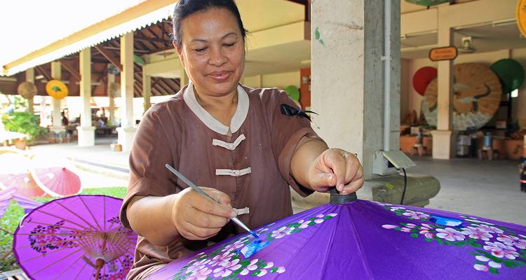 An artisan painting a traditional umbrella.