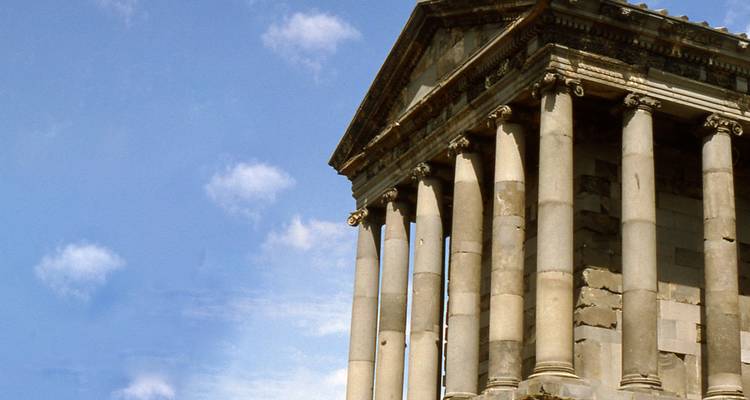 Antiker Tempel mit Säulen unter einem blauen Himmel.