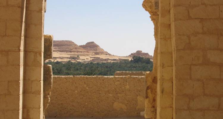 Uitzicht op woestijnlandschap door oude stenen structuur.