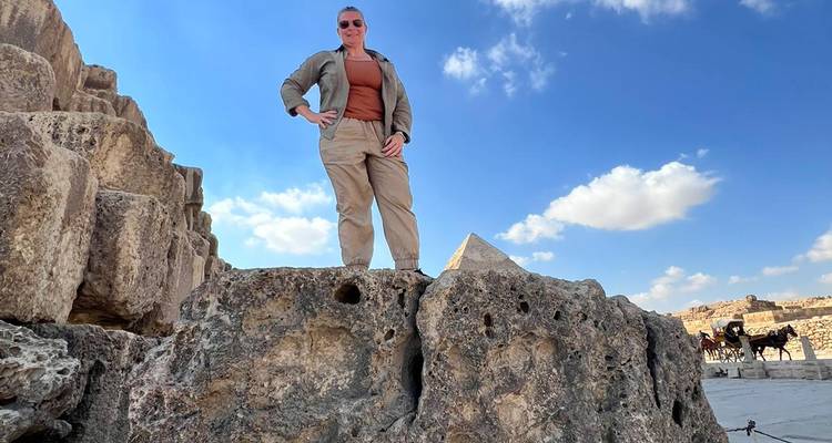 Persoon die op rotsen staat bij piramides.