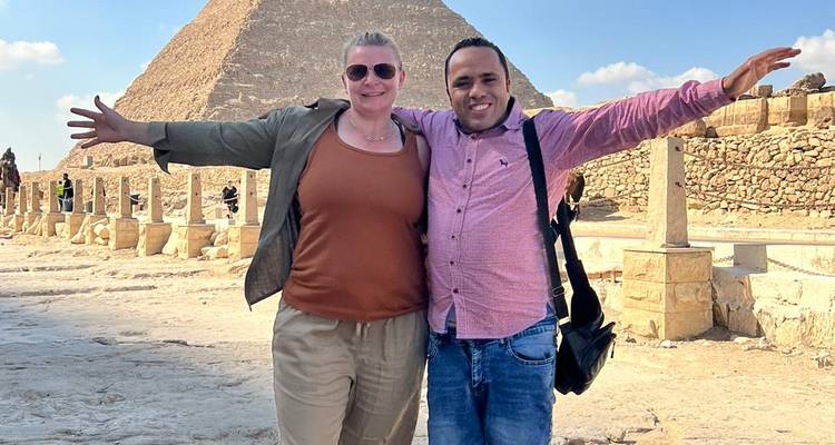 Twee mensen poseren met piramide achtergrond.