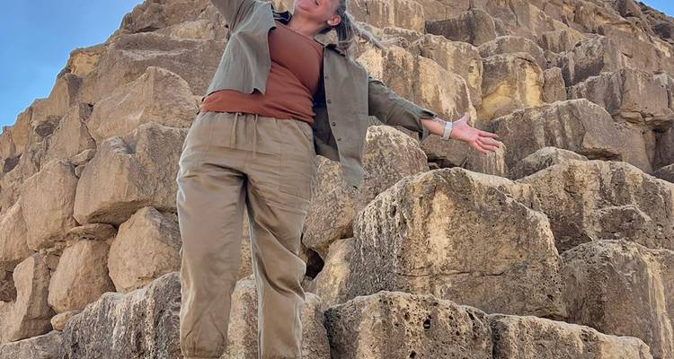 Persoon staand bij oude stenen.