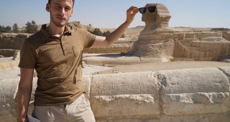 Persoon houdt speels een zonnebril boven de Sfinx.