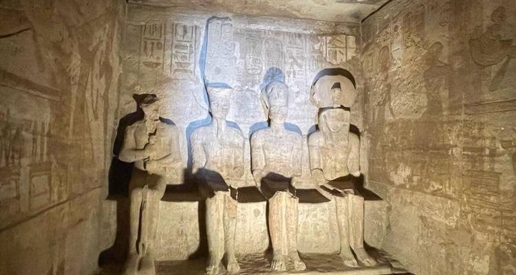 Carved statues inside a dimly lit temple chamber.