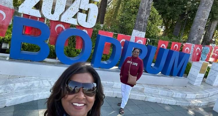 Two women posing in front of a Bodrum sign.