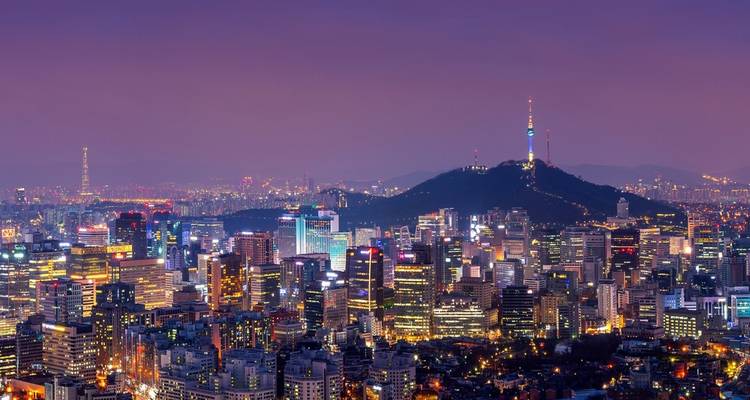 Night skyline of a city with a prominent tower.