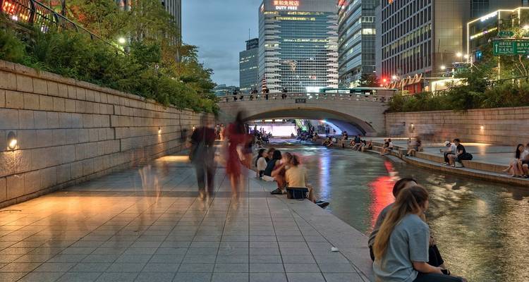 Urban canal scene with pedestrian activity in the evening.