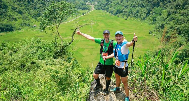 Deux personnes posent avec une vue sur des rizières en arrière-plan.