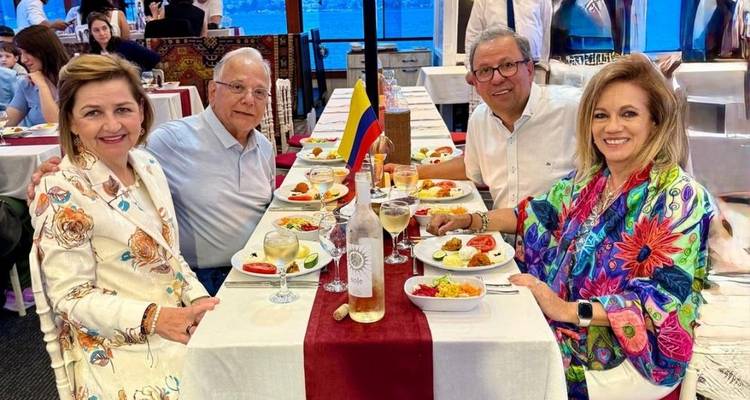 Cuatro personas en una mesa de comedor con comida en un restaurante.