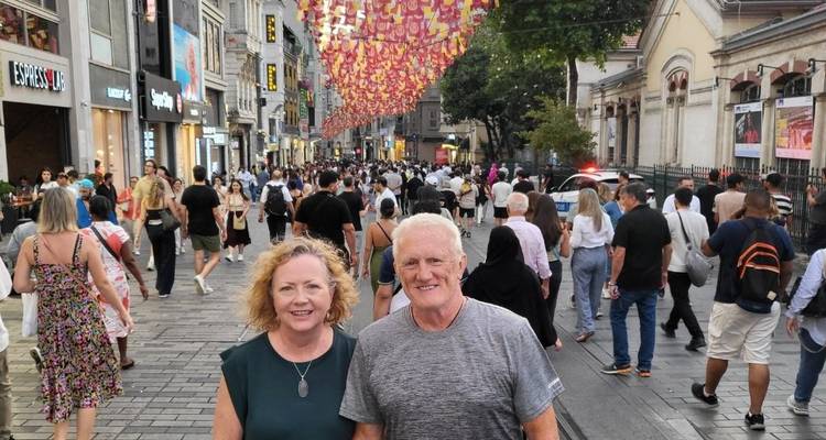 Een stel poseert op een drukke straat met decoratieve vlaggen.