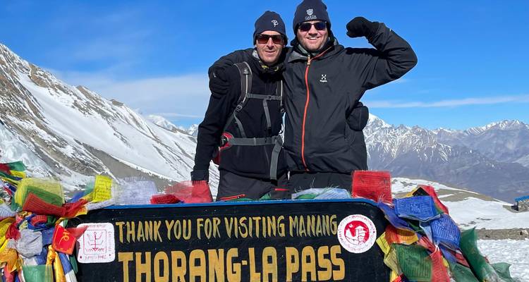 Zwei Personen posieren mit der Thorong La Pass Beschilderung.