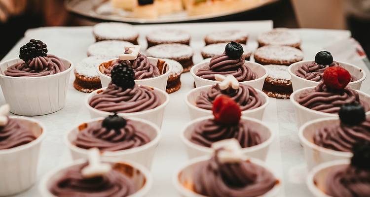 Eine Auslage von verschiedenen Cupcakes und Desserts auf einem Tablett.