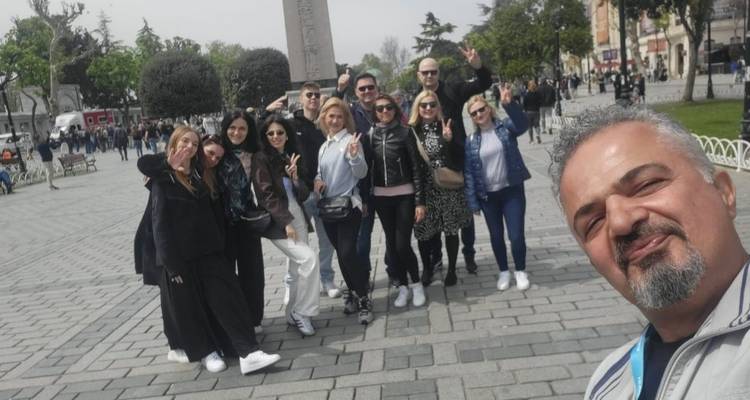 Grote groep mensen die een selfie maken op een openbaar plein.