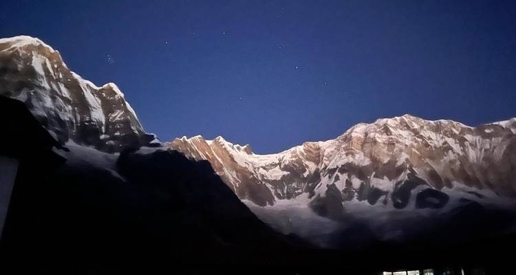 Gebirgszug in der Abenddämmerung mit sichtbarem Sternenhimmel.